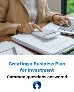 A woman works out sums on a calculator with her business plan for investment on her desk