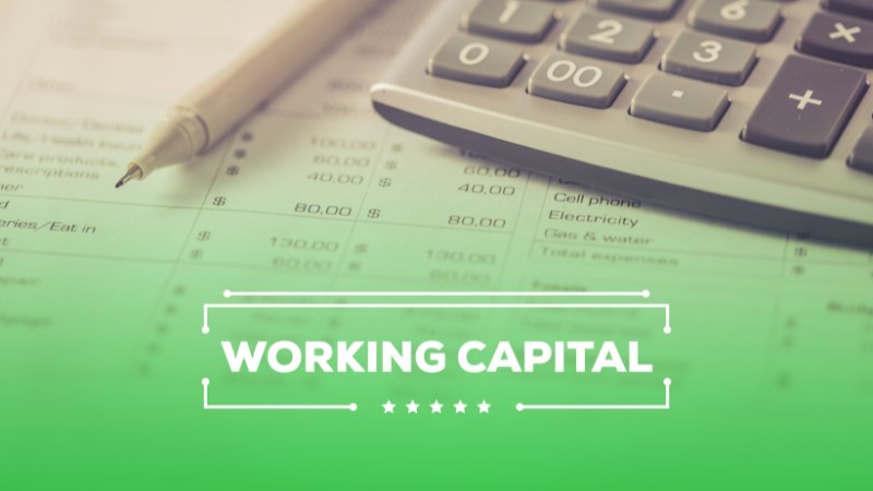 Image of a calculator and pen on a desk with some financial sheets, the text at the bottom says "Working Capital".
