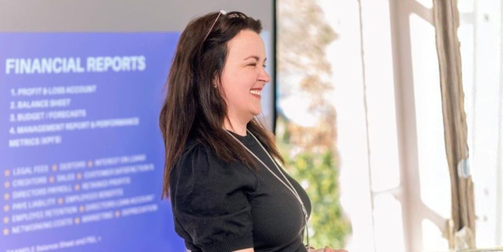 Logical BI founder Pauline Healy presenting in front of a screen and smiling
