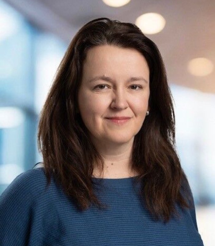 Headshot of CFO for Manufacturing specialist Pauline Healey. She is wearing a blue jumper and smiles at the camera.